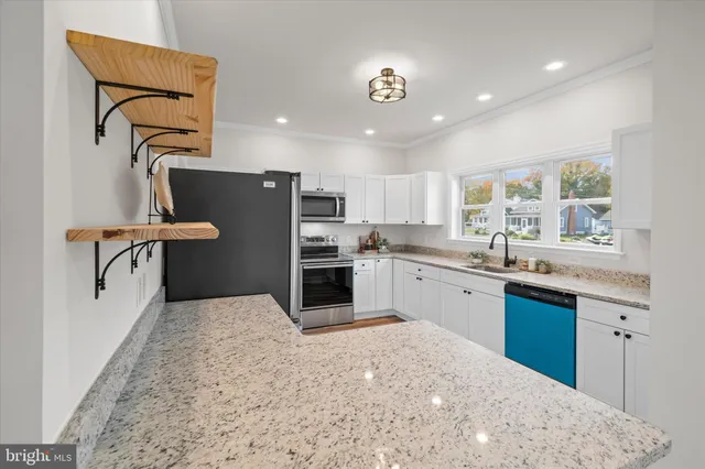 a kitchen with granite countertop white cabinets and window