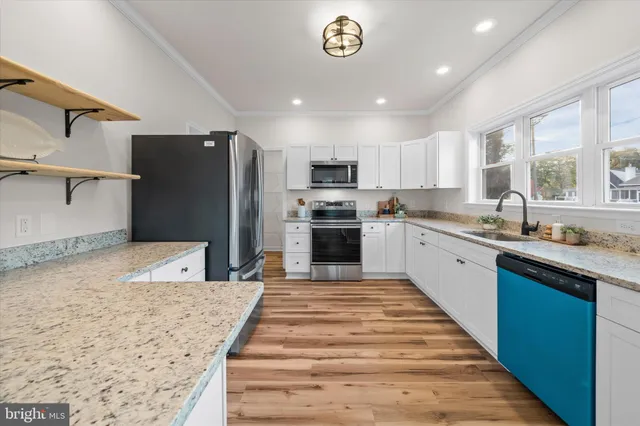 a kitchen with stainless steel appliances a refrigerator sink and white cabinets