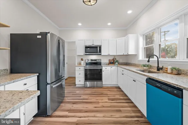 a kitchen with granite countertop a refrigerator stove and sink