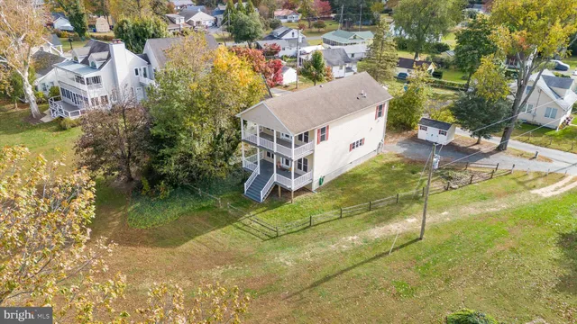 a view of a house with wooden deck and floor to ceiling window