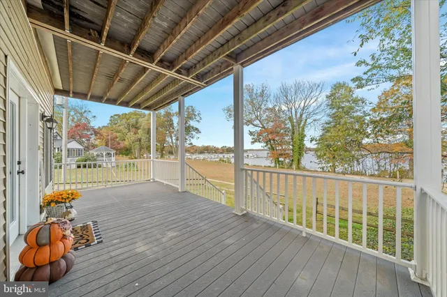 a view of kitchen with kitchen island microwave oven stove and white cabinets with wooden floor