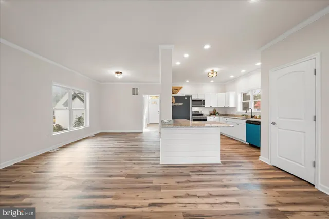 a view of a kitchen with wooden floor and a refrigerator