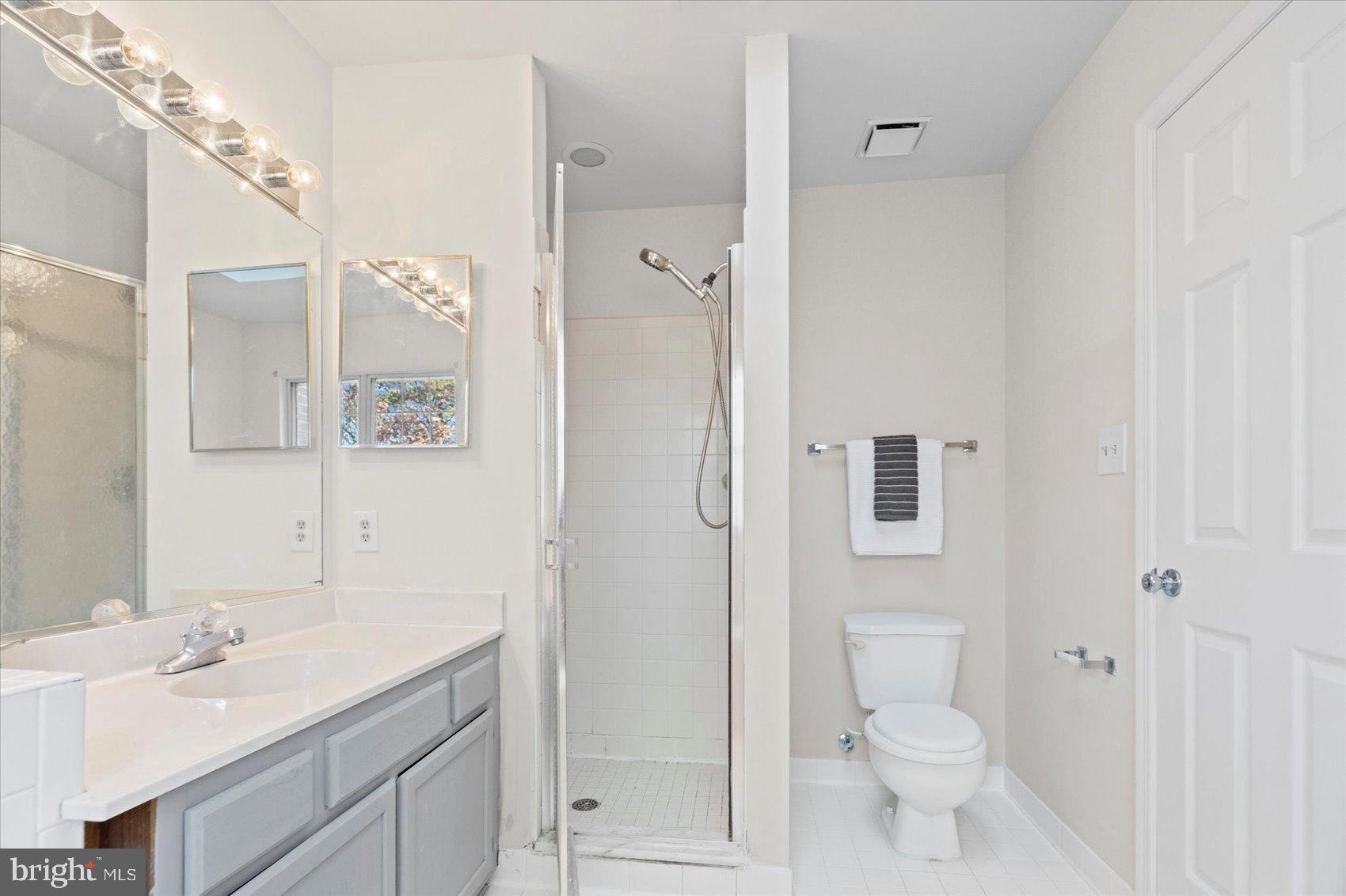 9317 Dortmund Court Laurel, MD 20708 - Photo 30 of 50 a bathroom with a sink a toilet a shower and a mirror