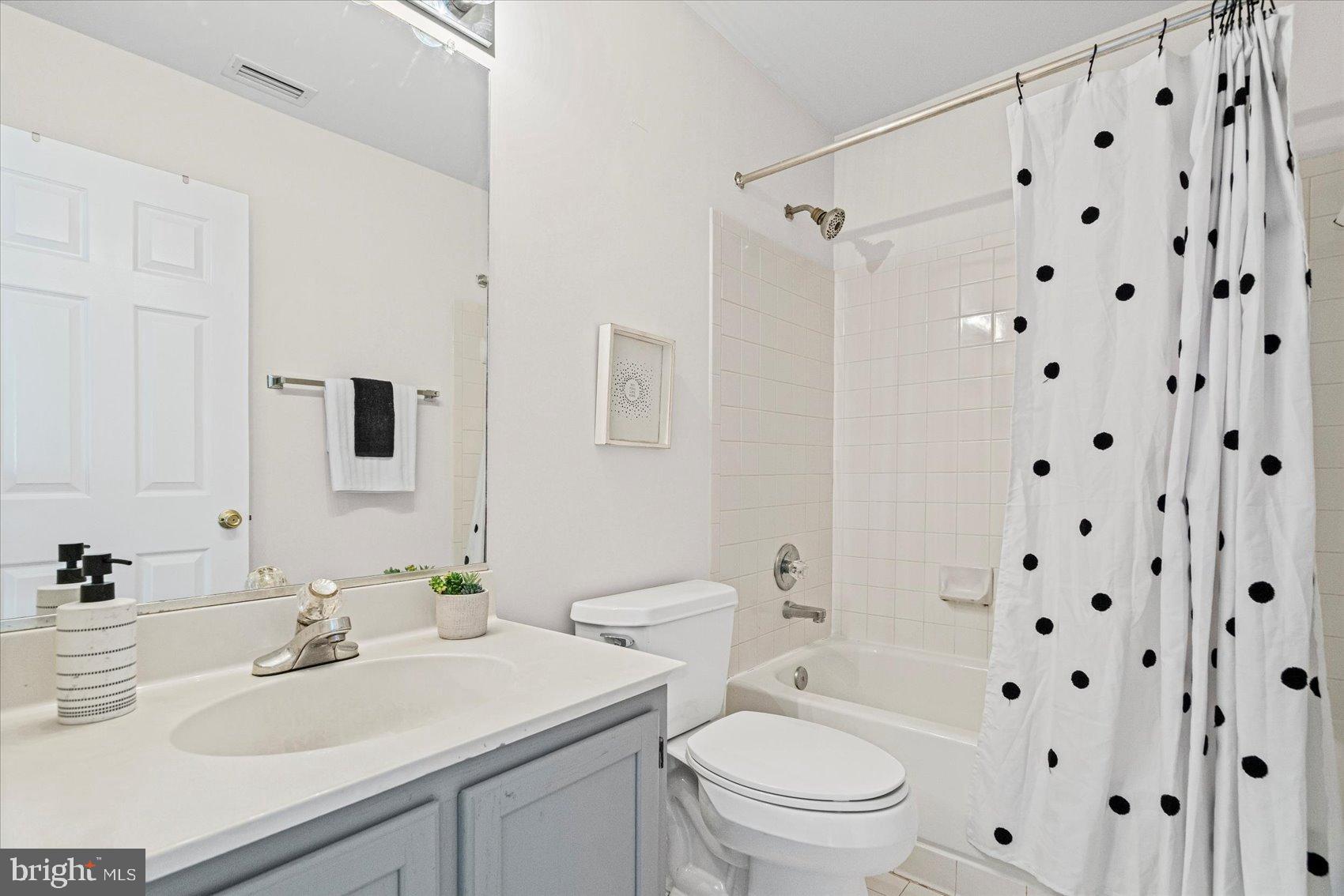 9317 Dortmund Court Laurel, MD 20708 - Photo 31 of 50 a bathroom with a sink a toilet a mirror a vanity and shower