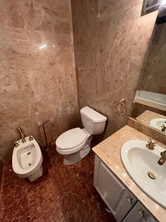 373 Highland Avenue, Unit 308 Somerville, MA 02144 - Photo 5 of 9 a bathroom with a toilet sink and mirror