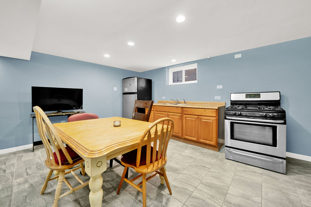 7234 South Ridgeway Avenue Chicago, IL 60629 - Photo 13 of 27 a kitchen with a stove a table and chairs