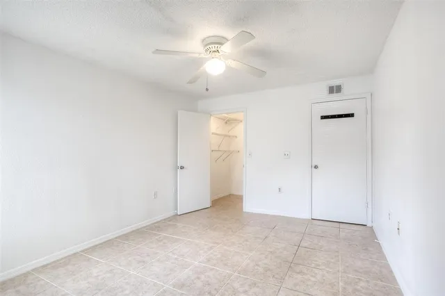 an empty room with fan and windows