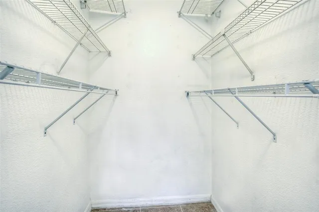 an empty room with fan and windows