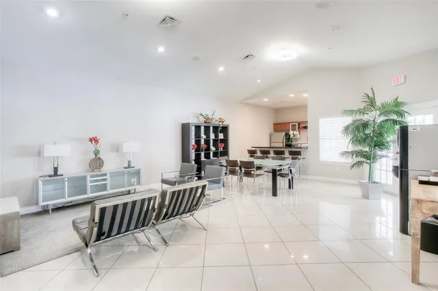 a living room with furniture a dining table and a potted plant