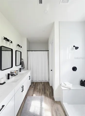 a bathroom with a bathtub sink mirror vanity and toilet