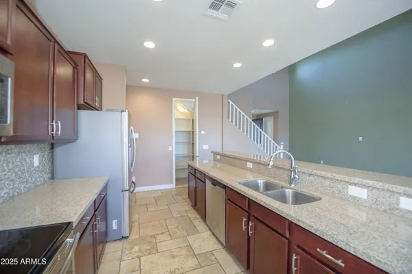 a kitchen with granite countertop stainless steel appliances lots of counter space and a sink