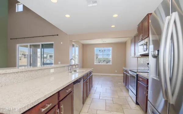 a kitchen with stainless steel appliances granite countertop a refrigerator and a sink