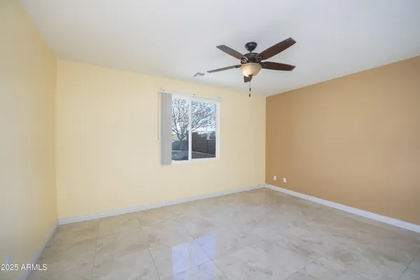 a view of a room with a ceiling fan and a window