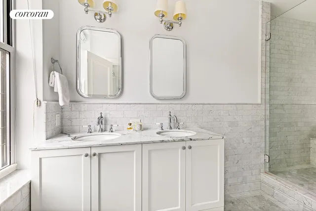 a bathroom with double vanity sinks and a mirror