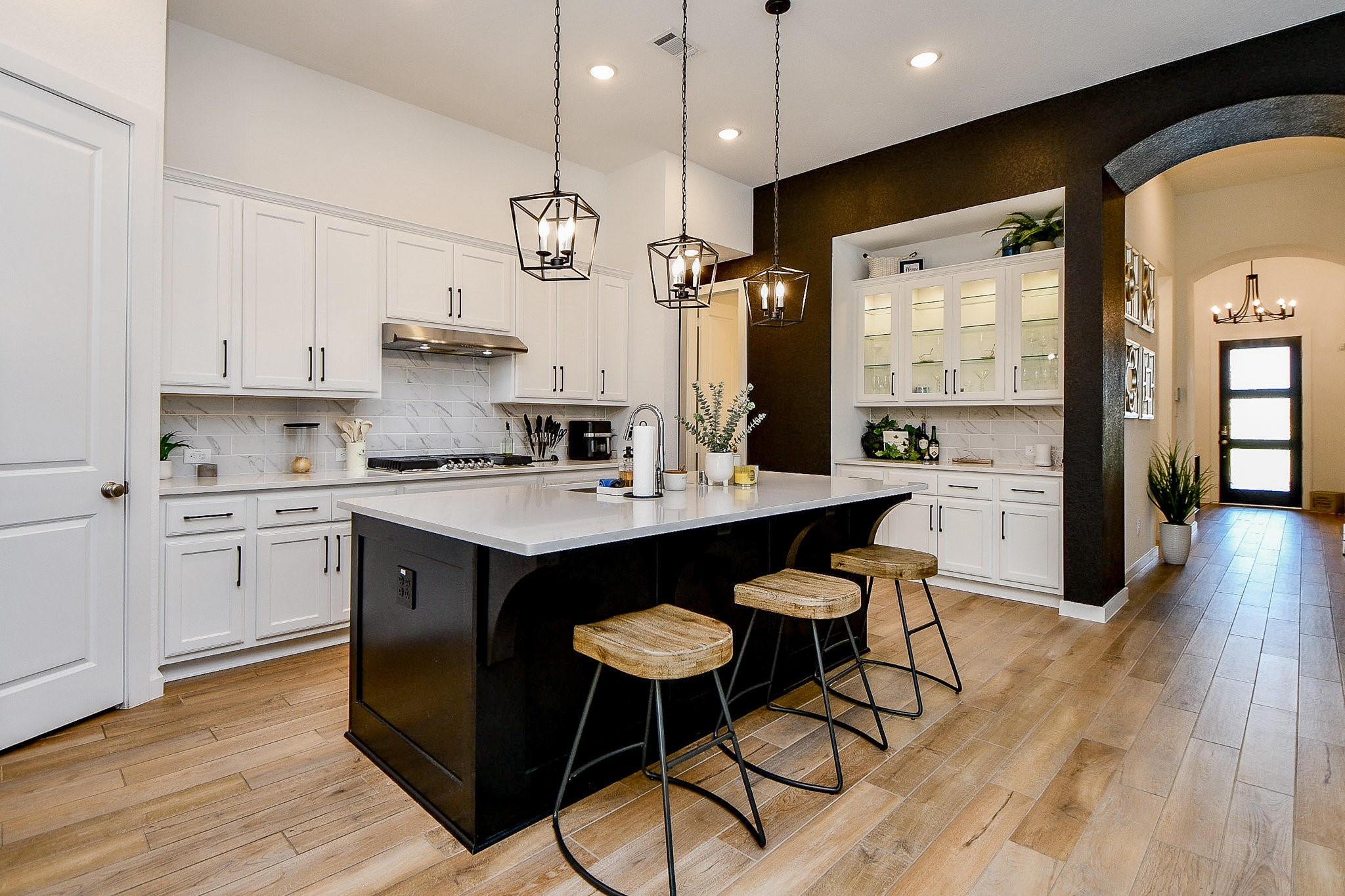 5102 Pomegranate Path Manvel, TX 77578 - Photo 16 of 33 a kitchen with a refrigerator a sink dishwasher a stove and white cabinets with wooden floor