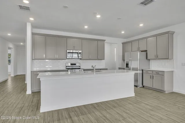 a kitchen with stainless steel appliances granite countertop a sink and cabinets