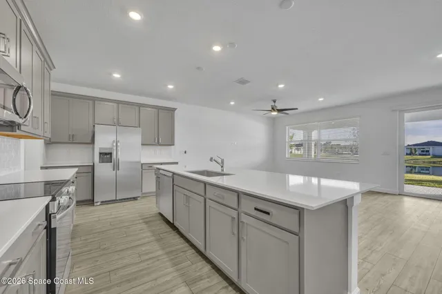a kitchen with white cabinets and sink