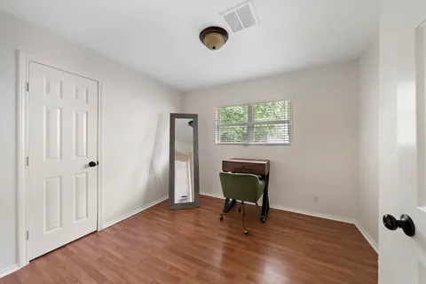 a view of a livingroom with wooden floor and a window