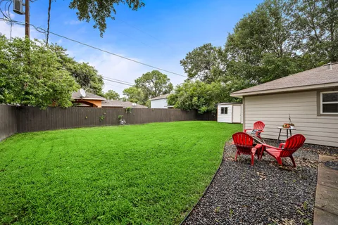 a view of backyard with wooden fence and a bench