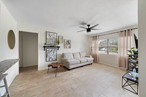 a living room with furniture a window and a potted plant