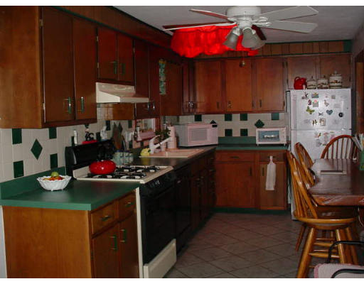 102 Folly Mill Road Salisbury, MA 01952 - Photo 3 of 9 a kitchen with a sink a stove and wooden cabinetry