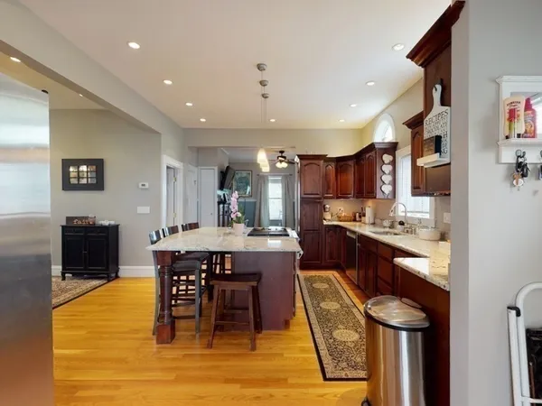 a kitchen with stainless steel appliances granite countertop table chairs sink and cabinets