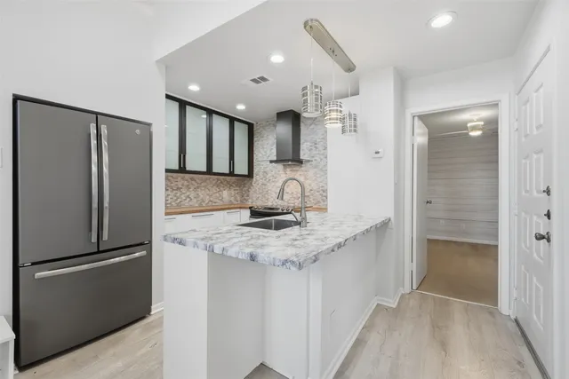 a kitchen with stainless steel appliances granite countertop a refrigerator and a sink