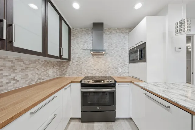 a kitchen with granite countertop a stove sink and cabinets