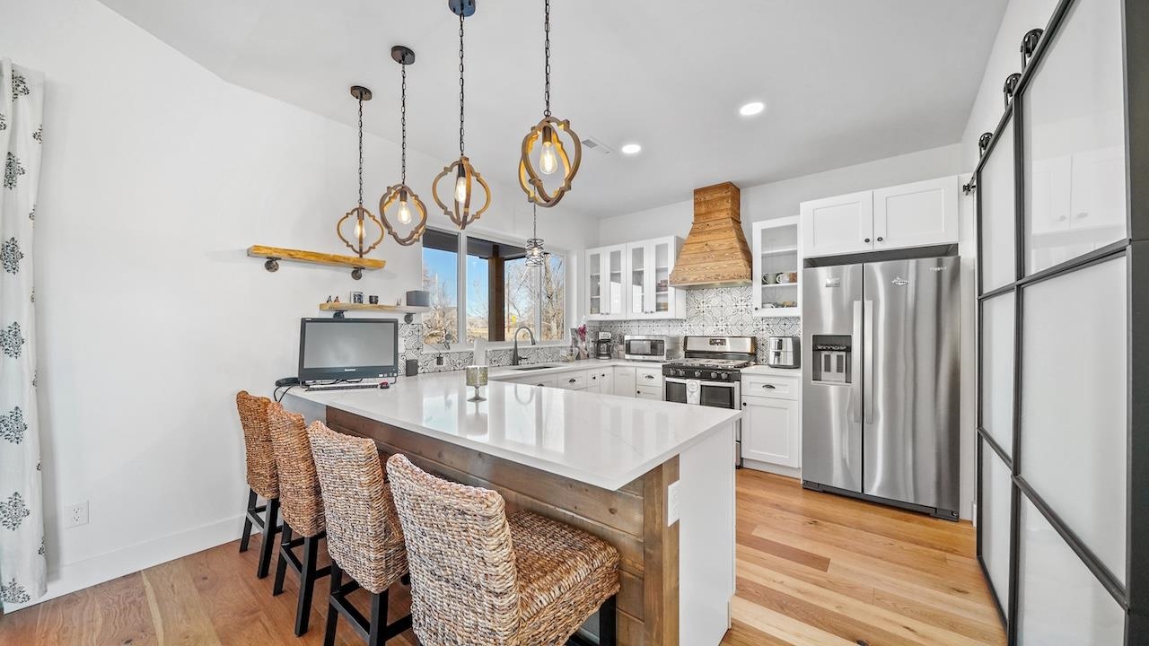 3439 D Road Palisade, CO 81526 - Photo 9 of 29 a kitchen with stainless steel appliances granite countertop a sink a stove and refrigerator with wooden floor
