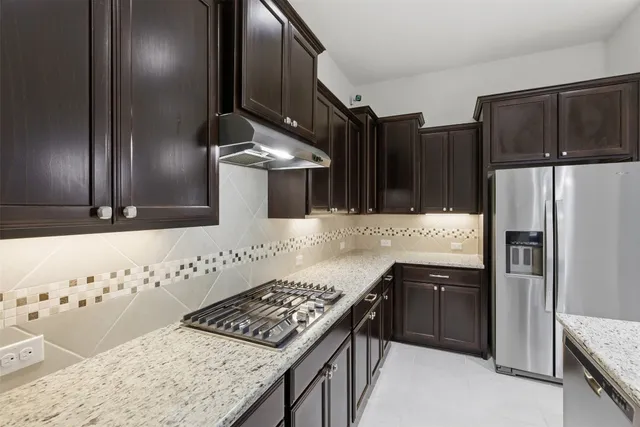 a kitchen with stainless steel appliances granite countertop a sink stove and refrigerator