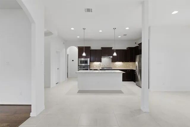 a large white kitchen with a large window and stainless steel appliances