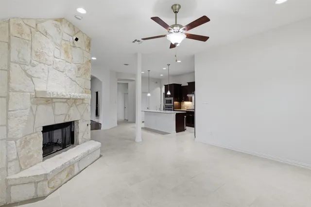an empty room with kitchen and fireplace