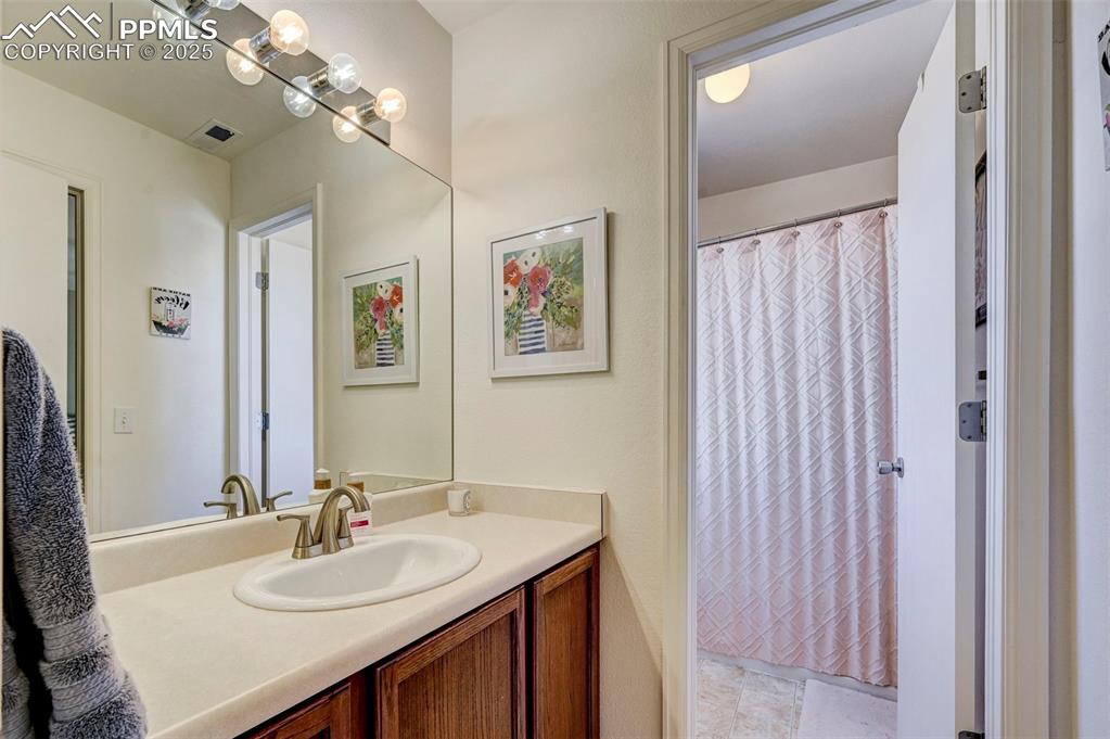 9332 Bethpage Road Peyton, CO 80831 - Photo 21 of 32 a bathroom with a double vanity sink and a mirror