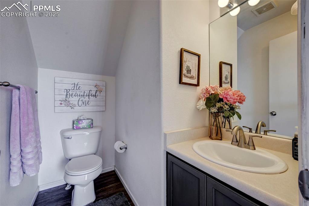 9332 Bethpage Road Peyton, CO 80831 - Photo 24 of 32 a bathroom with a toilet a sink and mirror