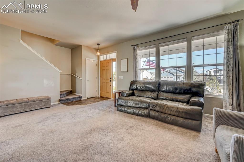 9332 Bethpage Road Peyton, CO 80831 - Photo 4 of 32 a living room with furniture and a floor to ceiling window