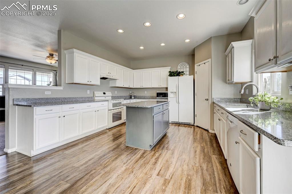 9332 Bethpage Road Peyton, CO 80831 - Photo 5 of 32 a large kitchen with stainless steel appliances granite countertop a lot of counter space and wooden floors