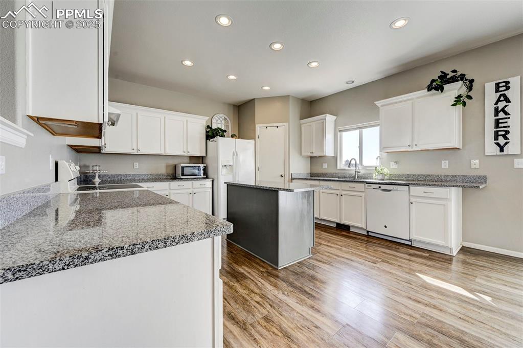 9332 Bethpage Road Peyton, CO 80831 - Photo 6 of 32 a kitchen with granite countertop a sink a counter top space stainless steel appliances and cabinets