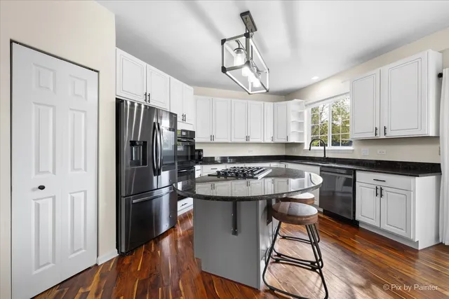 a kitchen with stainless steel appliances granite countertop a sink and a refrigerator