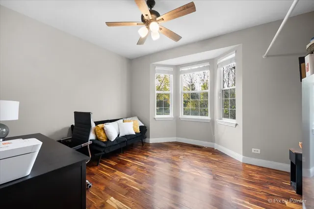 a view of a workspace with furniture and a book shelf