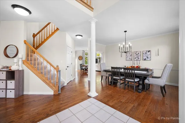 a view of a dining room and livingroom with furniture wooden floor a chandelier