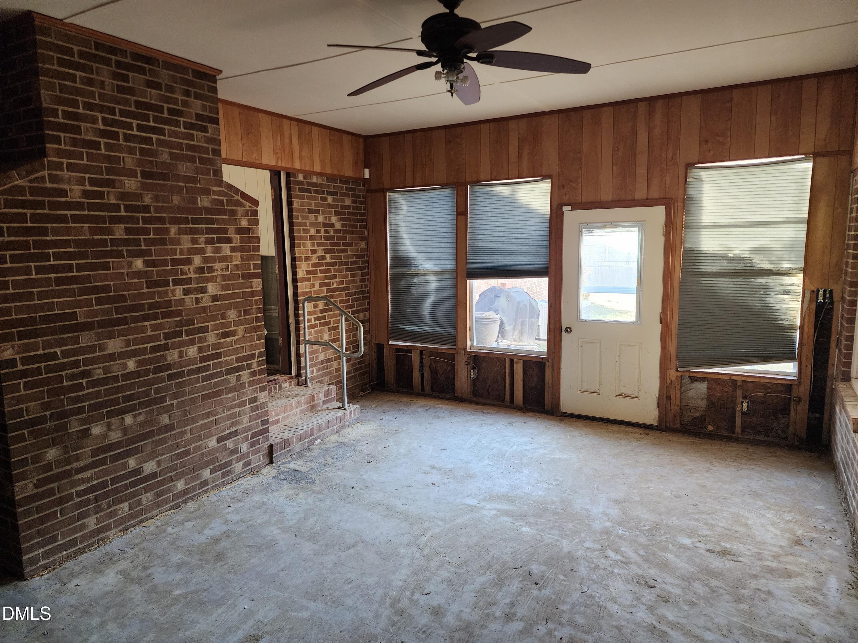 309 Rippling Stream Road Durham, NC 27704 - Photo 32 of 36 a view of an empty room with a fireplace and a ceiling fan