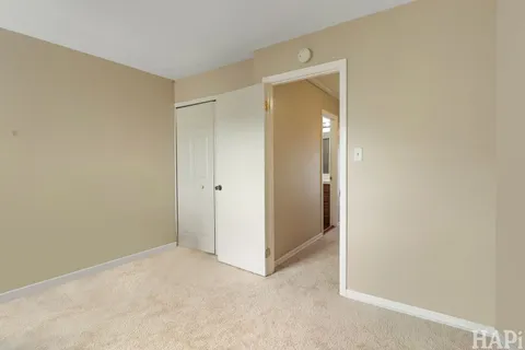 a view of an empty room with closet and mirror