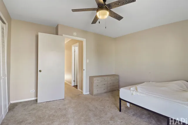 a bedroom with a bed and a chandelier fan