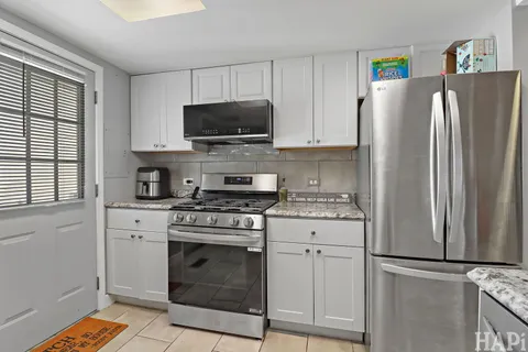 a kitchen with cabinets stainless steel appliances and a window