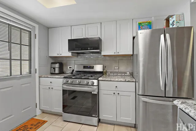 a kitchen with cabinets stainless steel appliances and a window
