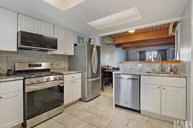 a kitchen with stainless steel appliances granite countertop a stove top oven microwave and refrigerator