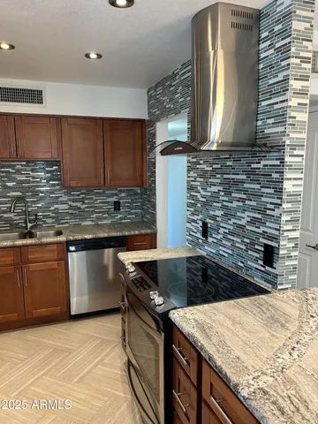a kitchen with granite countertop a sink and a stove