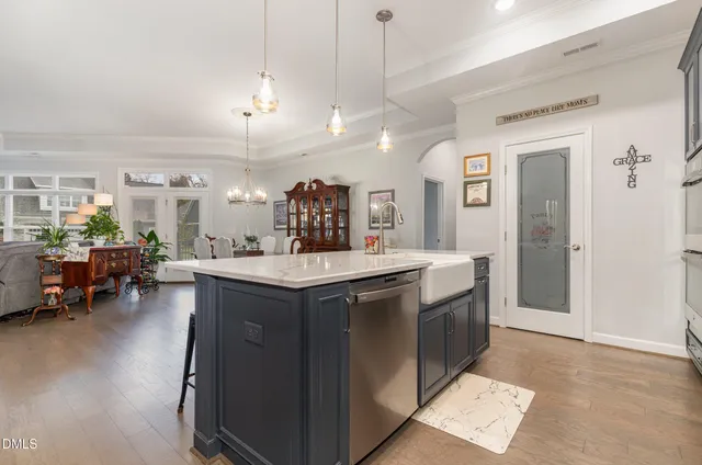 a kitchen with stainless steel appliances granite countertop a sink a counter space and a view of living room