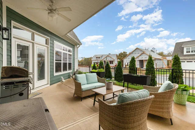 a view of a patio with couches chairs and a floor to ceiling window