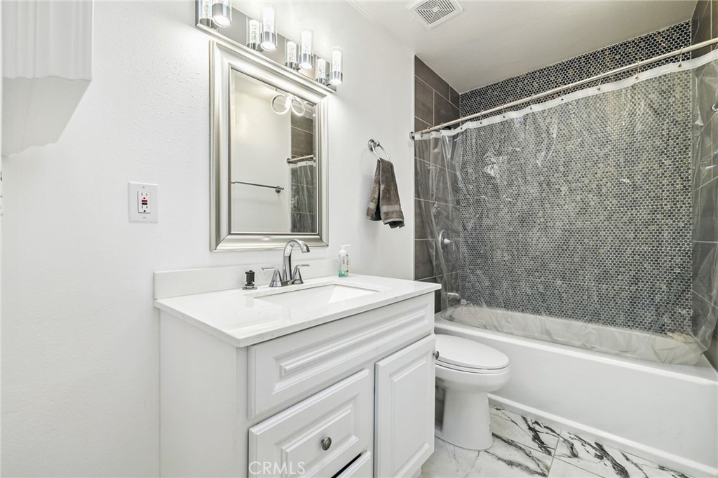 1349 Edgewood Way, Unit 49 Oxnard, CA 93030 - Photo 18 of 32 a bathroom with a sink a toilet a mirror a bathtub and shower